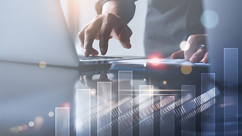 Hi-tech futuristic man using laptop with bar graph overlays