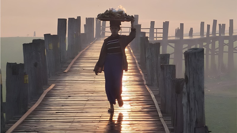 Woman walking on a dock carrying fish on her head